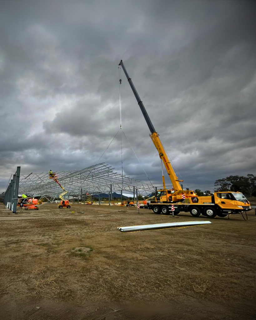 Crane lifting steel structures at Techspan project site in Kootingal.