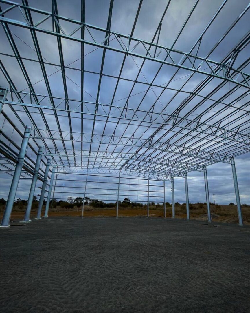 Ground-level view of a steel structure in progress at Geko Warehouse Kootingal, demonstrating safe lift planning techniques during warehouse construction.