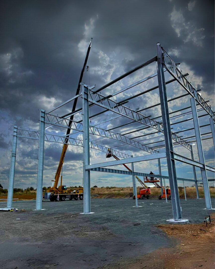 Steel framework installation for Geko Warehouse in Goulburn, with cranes and elevated work platforms lifting structural steel beams.