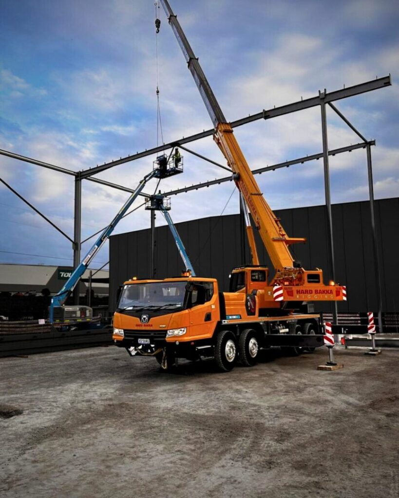 Hard Bakka Rigging crane lifting steel beams at warehouse construction site in Prestons.