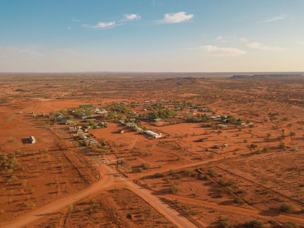 Aerial view of a remote community surrounded by the red landscape of Western Australia’s mining region.